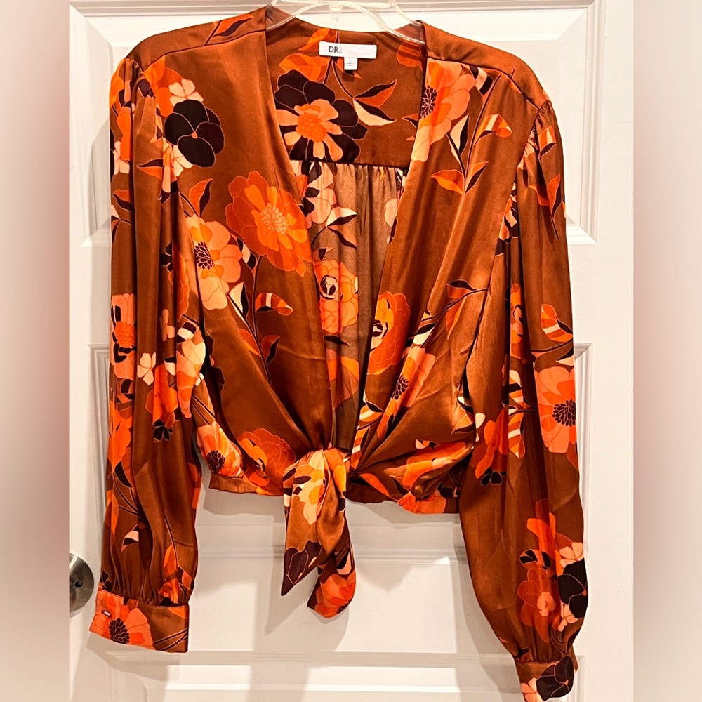 A beautiful silky floral top with loose parachute style sleeves. Tie front